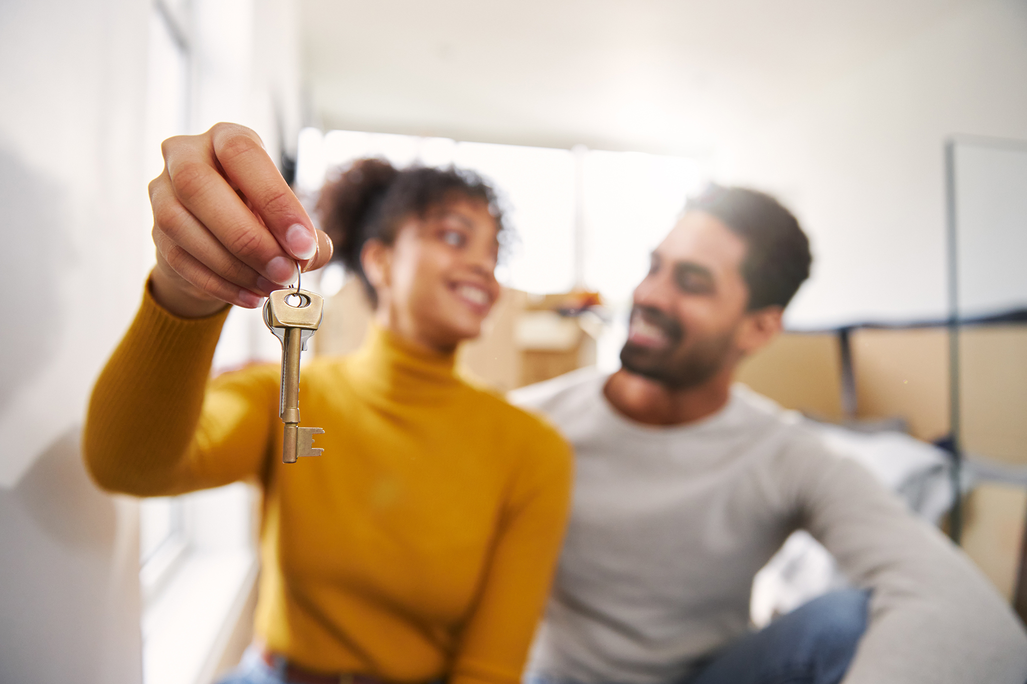 Woman and man holding a key to their first home